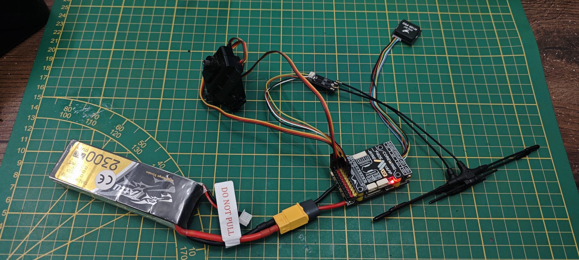 Stanowisko testowe Corewing F405 Wing V2 połączone z pakietem Tattu 2300mAh, modułem GPS M100-PRO i odbiornikiem RadioMaster XR4 Gemini