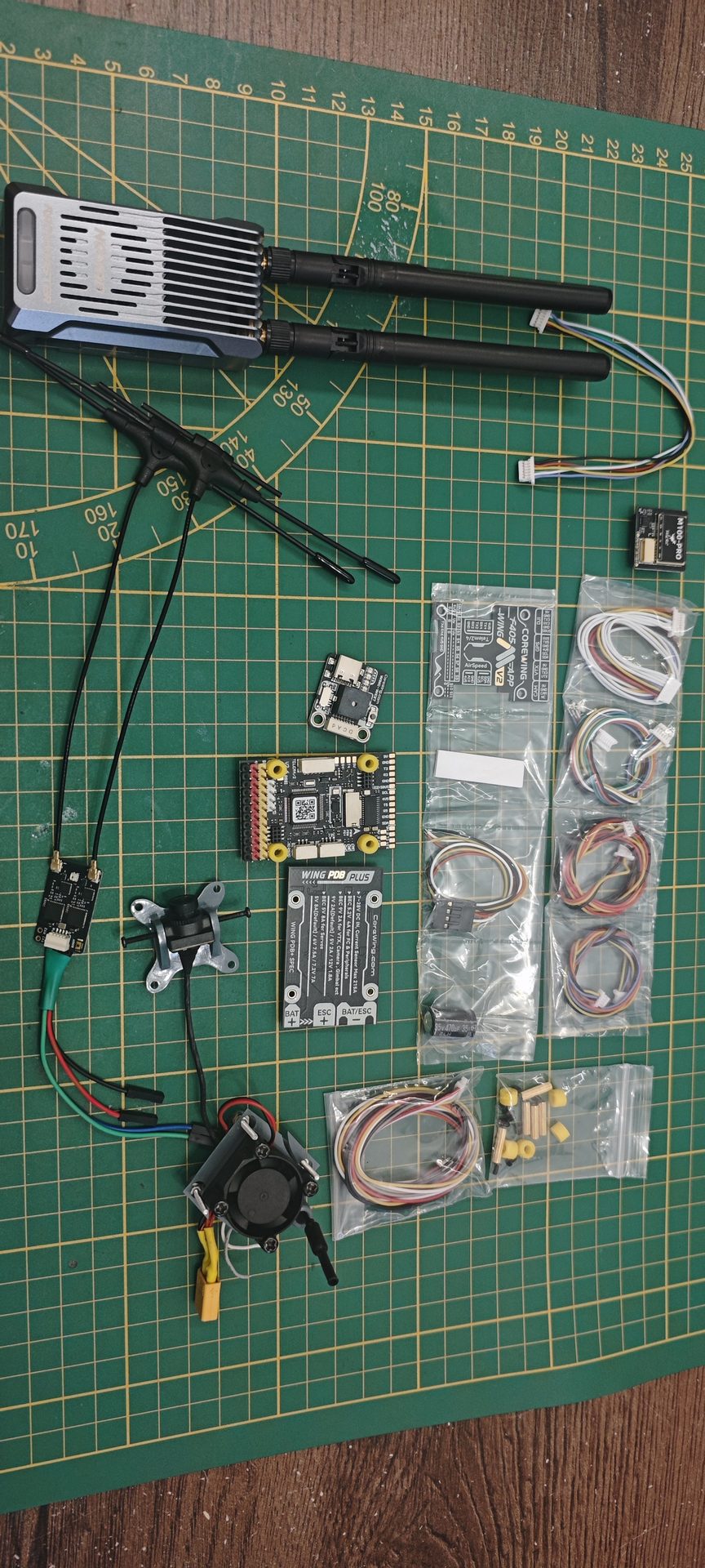 Kompletny ekosystem sprzętowy Tier 3: Nadajnik RadioMaster Nomad Gemini, odbiornik XR4 Dual Diversity, kontroler Corewing F405, moduł GPS M100-PRO oraz kamera FPV
